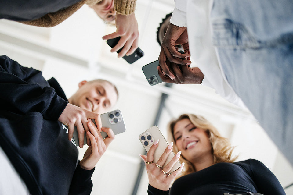 Vier mensen met een iPhone in hun hand