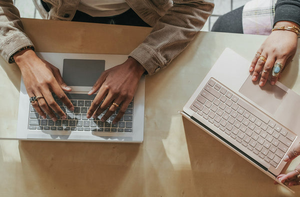 Twee mensen werken naast elkaar op verschillende laptops