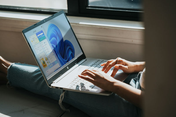 Iemand werkt bij het raam op een Windows 11-laptop